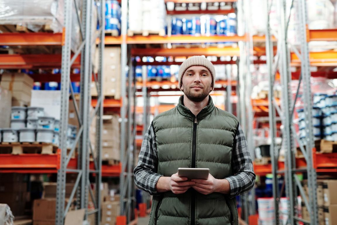 Warehouse worker with a tablet reviewing stocked goods